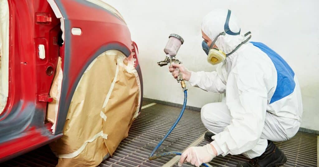 Technician performing car paint chip repair at West Delray Collision Center in Delray Beach