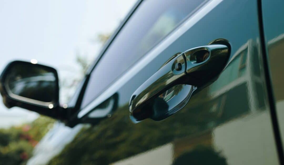 close-up of a car door handle and side panel reflecting sunlight — clean and dent-free finish.