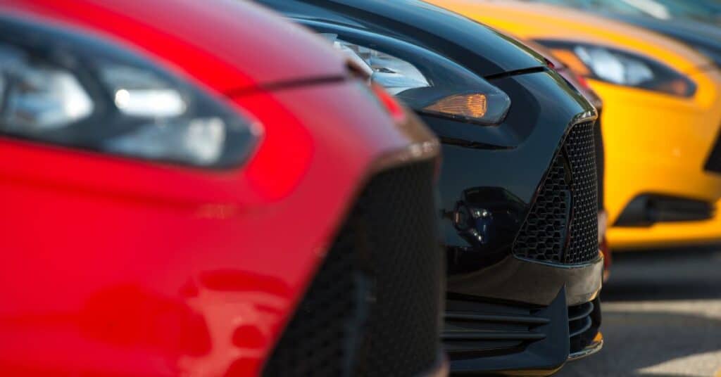 Paint Finish Comparison on Multiple Vehicles - West Delray Collision Center Close-up view of multiple cars in different colors parked side by side, highlighting paint finish differences.